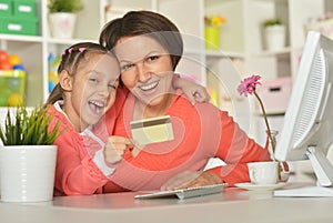 Girl with mother doing shopping online