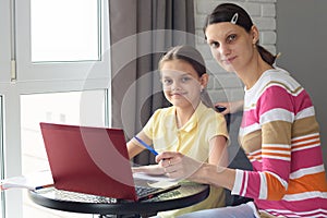 Girl and mother undergo interactive online education at home photo
