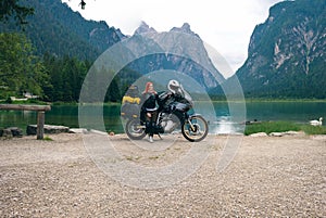 Girl motobiker in the center of the composition stands with tourÑˆÑ‚Ð¿ motorcycle. Extreme travel vacation, motorcyclist adventure