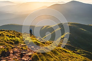 Girl on mountain peak with looking at beautiful mountain valley