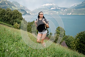 Girl in mountains. Woman hikers trekking in mountains. Young woman walking with backpacks in Alps lake. Woman with big