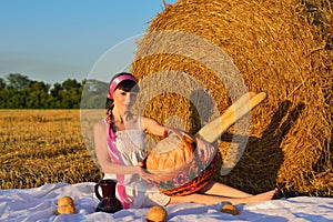 The girl on a mow with a basket of bread and a jug of milk