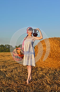 The girl on a mow with a basket of bread and a jug of milk