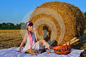 The girl on a mow with a basket of bread and a jug of milk