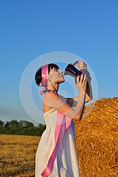 The girl on a mow drink a milk from jug