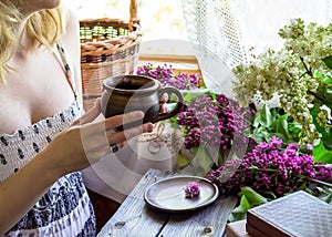 A girl with mug and lilac.