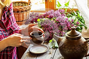 A girl with mug and lilac.