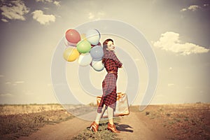 Girl with multicolored balloons and bag