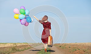 Girl with multicolored balloons and bag