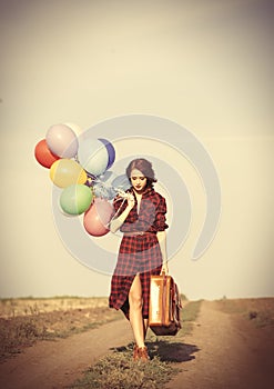 Girl with multicolored balloons and bag