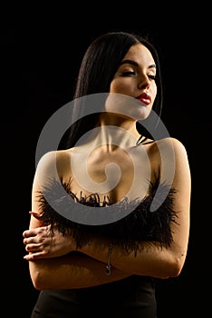 Girl with naked shoulders posing over black background. Portrait of elegant young woman in black elegant dress. skincare