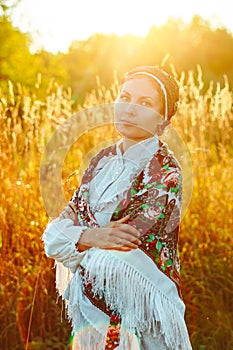 A girl in a national costume at sunset