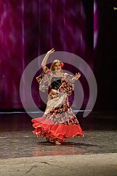 A girl in a national dress dances a gypsy dance