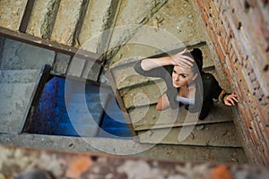 Girl near the brick wall in military style.