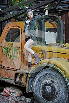 Girl near the brick wall in military style.