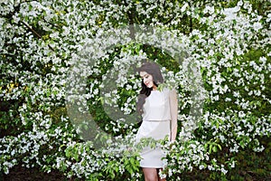 Girl near a bush of white flowers