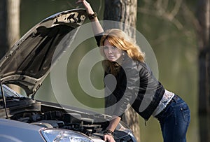Girl near the car with an open hood.