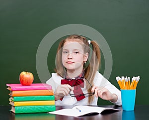 Girl near empty school green chalkboard