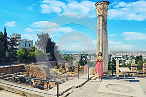 A girl near a Roman column in Carthage. Tourists at the Museum excavations of the ancient city in Tunisia photo