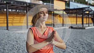 Girl near the sea doing yoga on a beach at sunrise