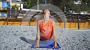 Girl near the sea doing yoga on a beach at sunrise