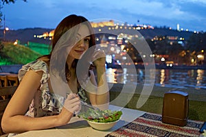 Girl, night, dinner at an outdoor cafe
