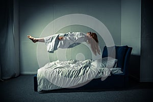 Girl in nightgown sleeping and levitating photo