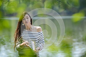 Girl with a notebook in park near the river