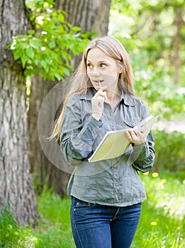 Girl with notebook and pen in park