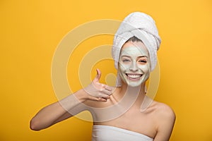 Girl with nourishing facial mask showing
