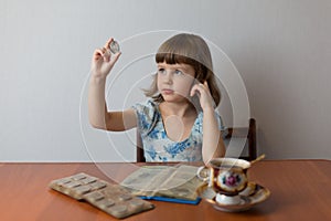 Girl numismatist examines a collection of coins