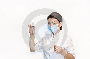 Girl nurse, young woman, lady doctor n white coat, sterile white latex gloves, mask holds syringe for injection, vaccination, pain