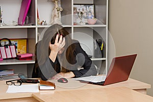 Girl in the office clutching her head