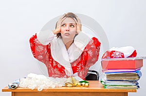 Girl office staff member dressed as Santa Claus grabs his head at his desk