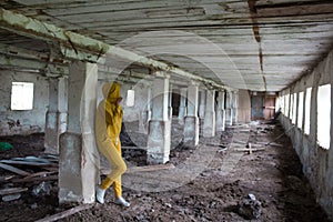 A girl in an old abandoned scary room like a barn or stable. An abandoned factory barn and stable where cows and horses