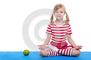 Girl with open eyesand apple practice yoga