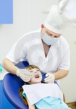 Girl with open mouth while it being examined by de