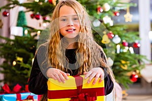 Girl opening present on Christmas day