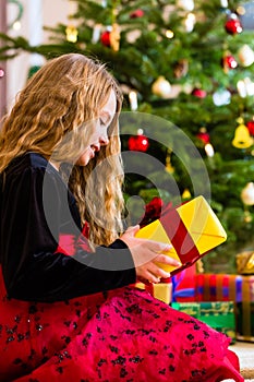 Girl opening present on Christmas day