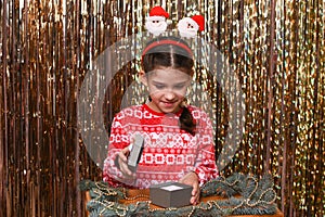 a girl opens a gift box on a golden background.