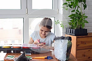 Girl opens a package with pots for seedlings