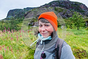 A girl in an orange cap smiles against the backdrop