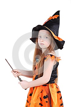 Girl in orange costume of witch for Halloween holds wand