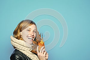 Girl with orange leaves on blue background.