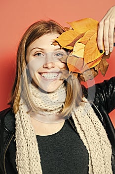 Girl with orange leaves on orange background.