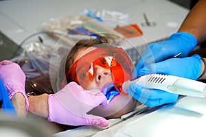 Girl in Orange Protective Glasses Gets Teeth Sealed