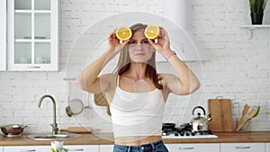 Girl with orange slices in her hands closes her eyes.