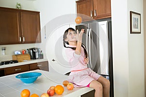 Girl with oranges in kitchen