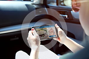 Girl is ordering food on the internet using an app while standing in a traffic jam