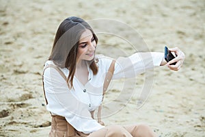 Girl outdoors texting on her mobile phone. Girl with phone. Portrait of a happy woman text sms message on her phone.